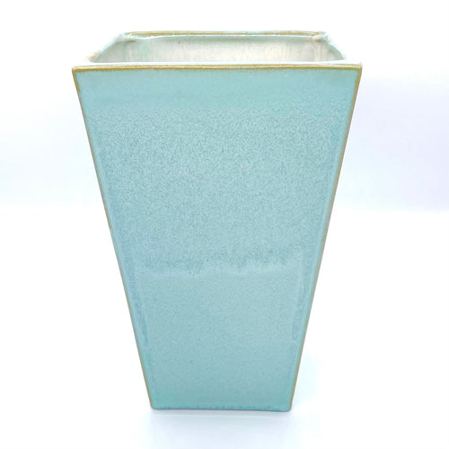 Auf dem Bild siehst du eine Keramik Vase. Sie ist in der Farbe grün.
