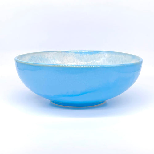 Auf dem Bild siehst du eine blaue Schüssel. Sie ist aus Keramik hergestellt. Das Geschirr ist eine Art tiefer Teller. 
